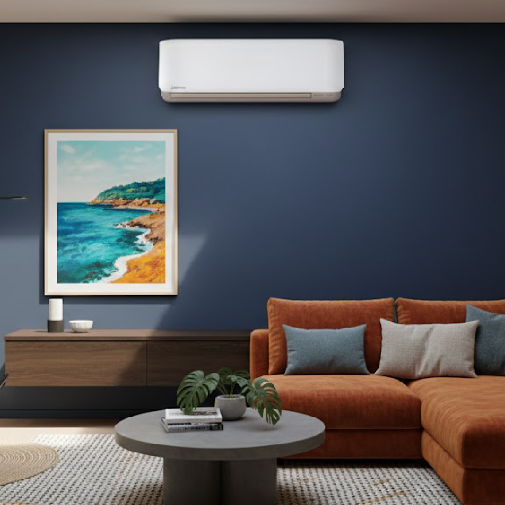 wall-mounted white Mitsubishi Heavy Industries (MHI) 2.5kW split system air conditioner installed on a dark navy blue accent wall in a modern living room with a terracotta sectional sofa and coastal artwork.